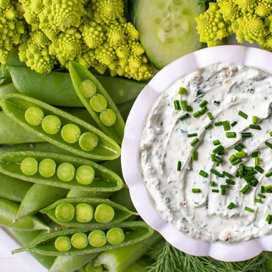 Fresh peas, romanesco cauliflower, cucumber, and celery with a bowl of Seven Onion Dip