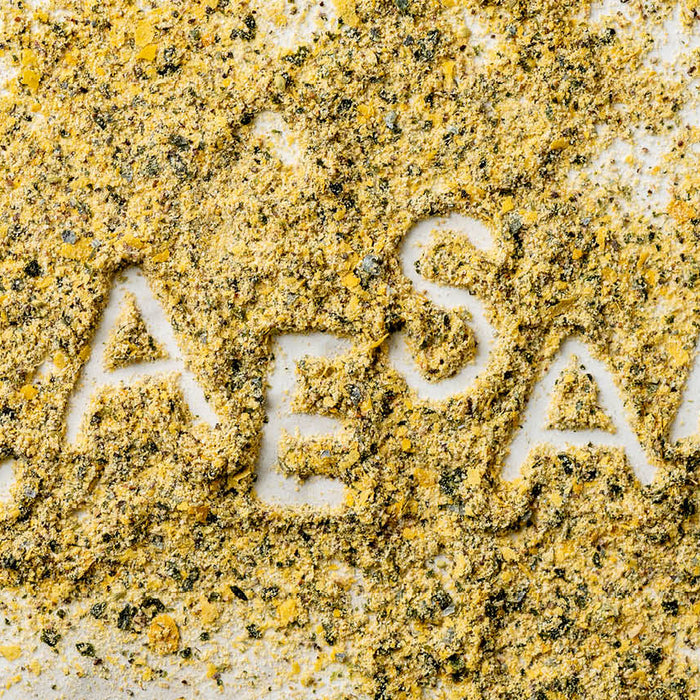 The word Caesar written inside a spill of Caesar Seasoning