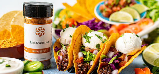 Jar of Taco Seasoning with three tacos and taco toppings