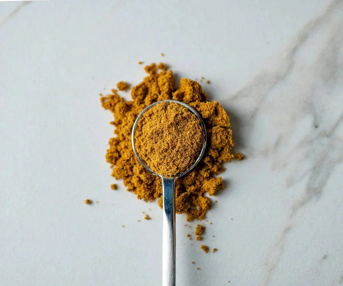 Spoon on white background with whole cumin seeds