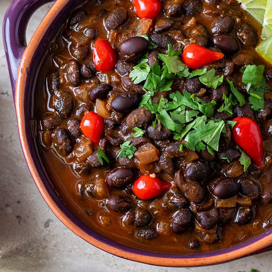 Jar of Peruvian Chile Lime Seasoning with a bowl of black bean soup