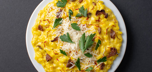 Overhead view of Saffron & Chanterelle Risotto with herb and cheese garnish