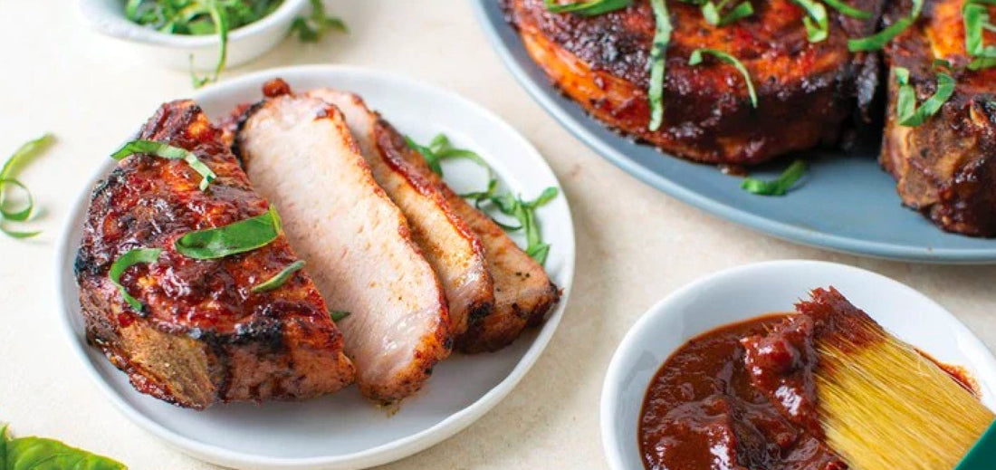 Three Memphis Style Dry Rubbed Ribs on a plate with a red napkin and lager platter to the right