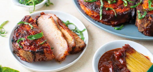 Three Memphis Style Dry Rubbed Ribs on a plate with a red napkin and lager platter to the right