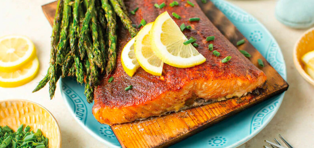Grilled cedar plank salmon with asparagus and lemon wedges