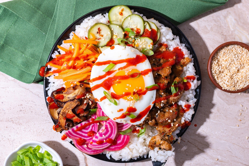 Overhead Korean BBQ Bibimbap bowl garnished with a fried egg and sesame seeds