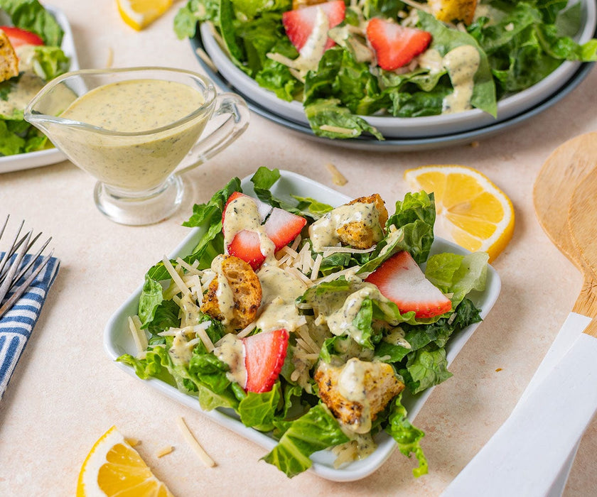 Strawberry Caesar Salad plates with lemon wedges and caesar dressing