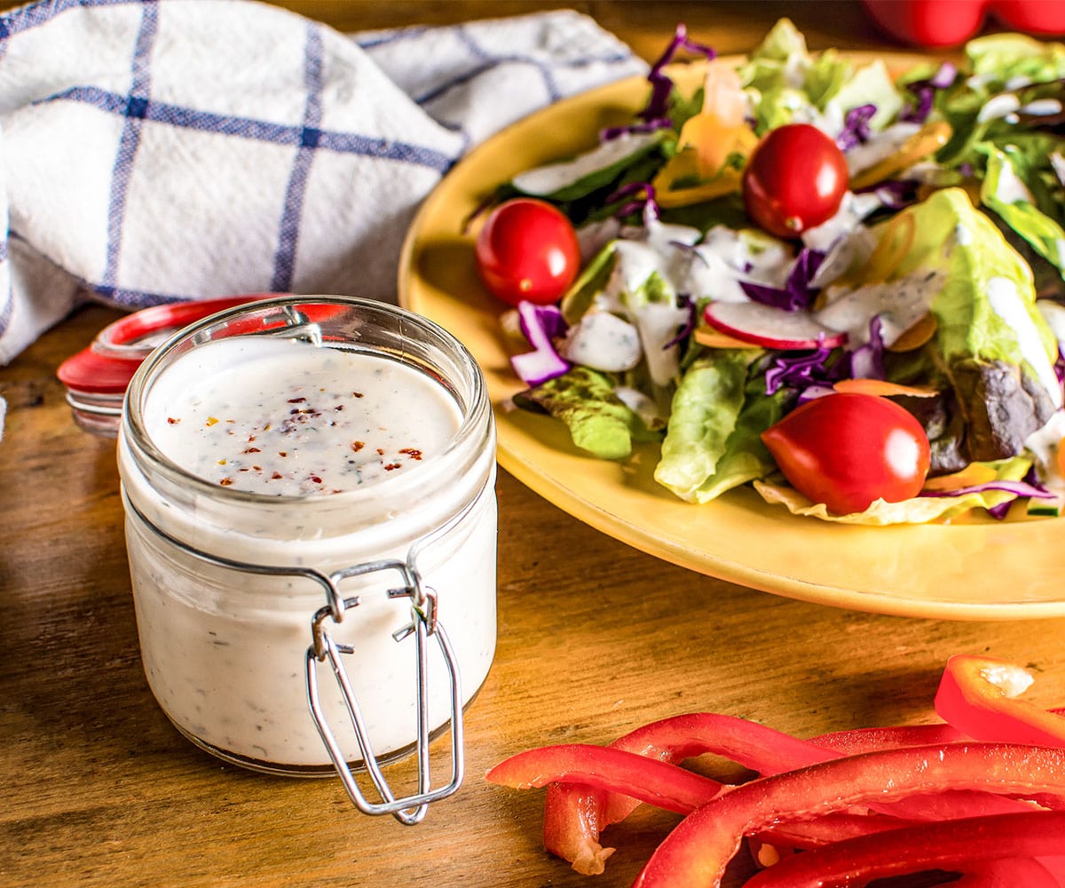 table setting of salad and a mason jar of buttermilk ranch.